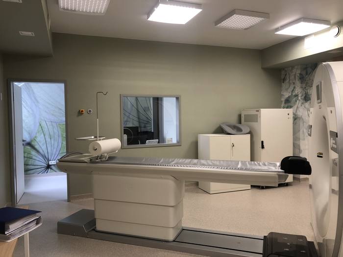 The examination room with the patient table and the leaded glass window facing the control room.
