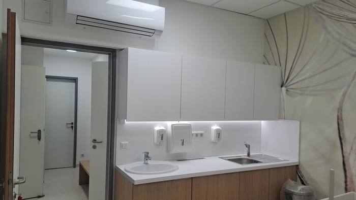 Leaded glass window onto the examination room, with the workstation and a radiation-shielded door.